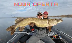 Dwóch wędkarzy na łodzi z ogromnym szczupakiem. To efekt udanego połowu w fishery fishing Frydman.