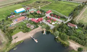 Malownicza jeziorna osada Gnojewo z piaszczystą plażą, pomostami i licznymi budynkami wypoczynkowymi.