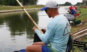 Wędkarz z haczykiem z włosem przygotowuje się do łowienia ryb nad kanałem.