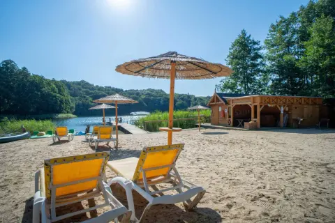 Piękna plaża z leżakami i parasolami nad jeziorkiem. Drewniana sauna zaprasza do relaksu. Idealne miejsce na agroturystykę nad jeziorkiem.
