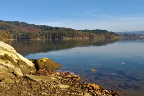 Kamieniste brzegi jeziora, lasy na wzgórzach i spokojna tafla wody tworzą idealne miejsca do wędkowania.