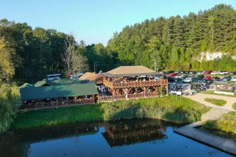 Drewniane restauracje nad wodą, pełne gości. Sprawdź pstrągowo menu cennik i zaplanuj wizytę.