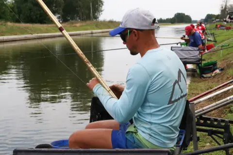 Wędkarz z haczykiem z włosem przygotowuje się do łowienia ryb nad kanałem.