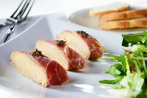 Kawałki pasztetu z wątróbki zawinięte w szynkę parmeńską, posypane ziołami. Idealne na przystawkę, zastanawiasz się, jaka wątróbka najlepsza?
