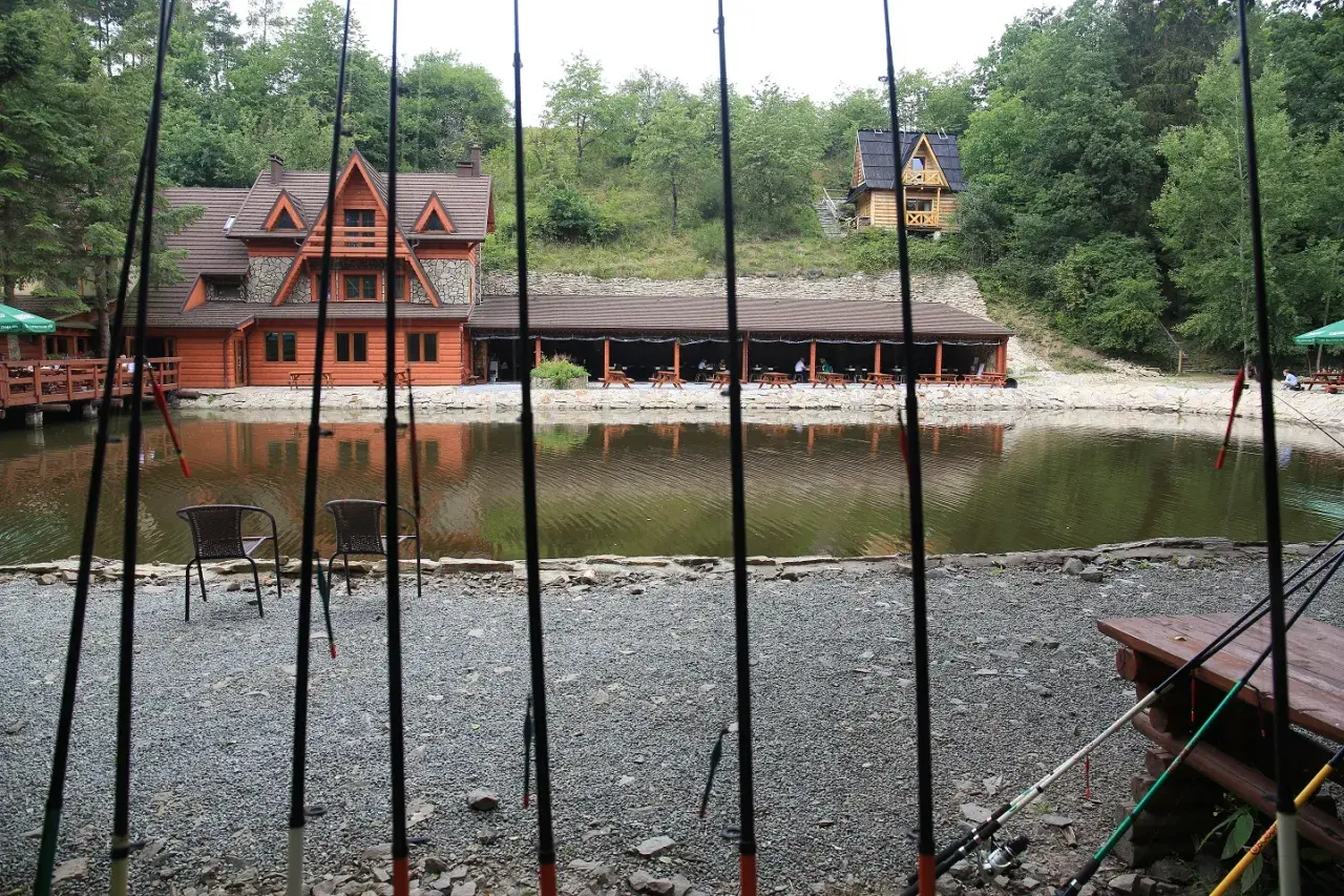 Wędki czekają nad jeziorem. Malownicze łowisko komercyjne dolnośląskie z drewnianymi domkami i zadaszoną restauracją.