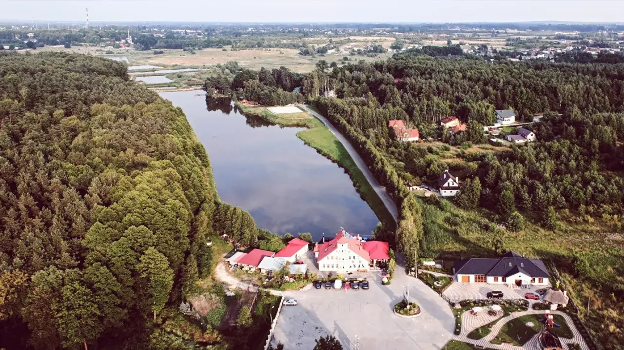 Malownicze łowisko karpik z domkami w otoczeniu lasu i jeziora.
