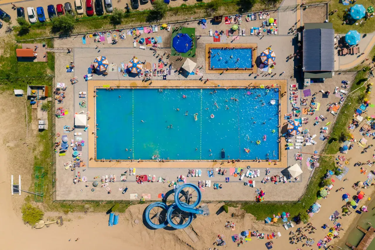 Wakacyjny relaks w Jurków, mała Chorwacja. Ludzie odpoczywają na plaży i kąpią się w basenie.