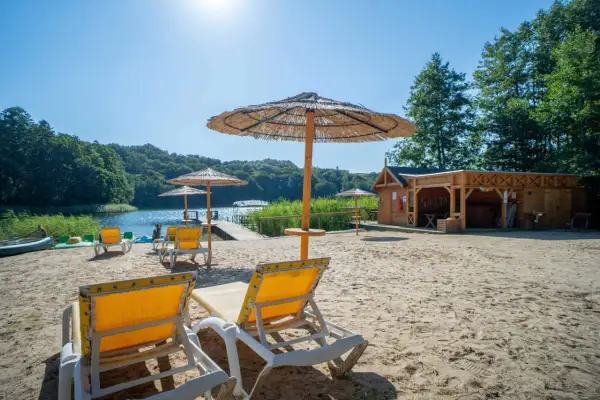 Piękna plaża z leżakami i parasolami nad jeziorkiem. Drewniana sauna zaprasza do relaksu. Idealne miejsce na agroturystykę nad jeziorkiem.