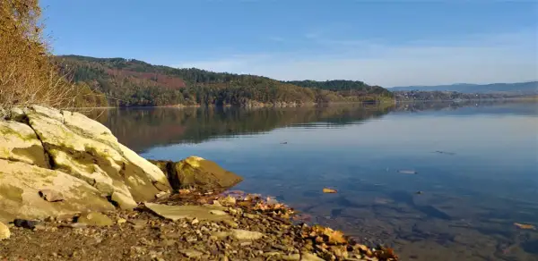 Kamieniste brzegi jeziora, lasy na wzgórzach i spokojna tafla wody tworzą idealne miejsca do wędkowania.