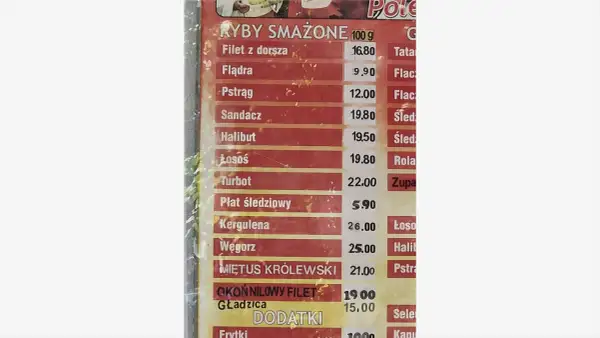 Cennik ryb smażonych: dorsz 16.80, flądra 9.90, pstrąg 12.00, sandacz 19.80, halibut 19.50, łosoś 19.80, turbot 22.00, płat śledziowy 5.90.