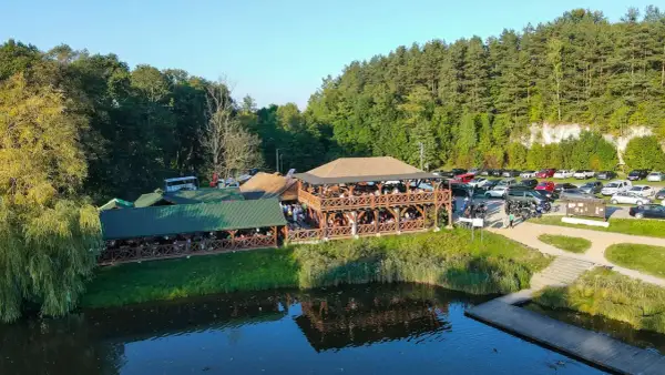Drewniane restauracje nad wodą, pełne gości. Sprawdź pstrągowo menu cennik i zaplanuj wizytę.
